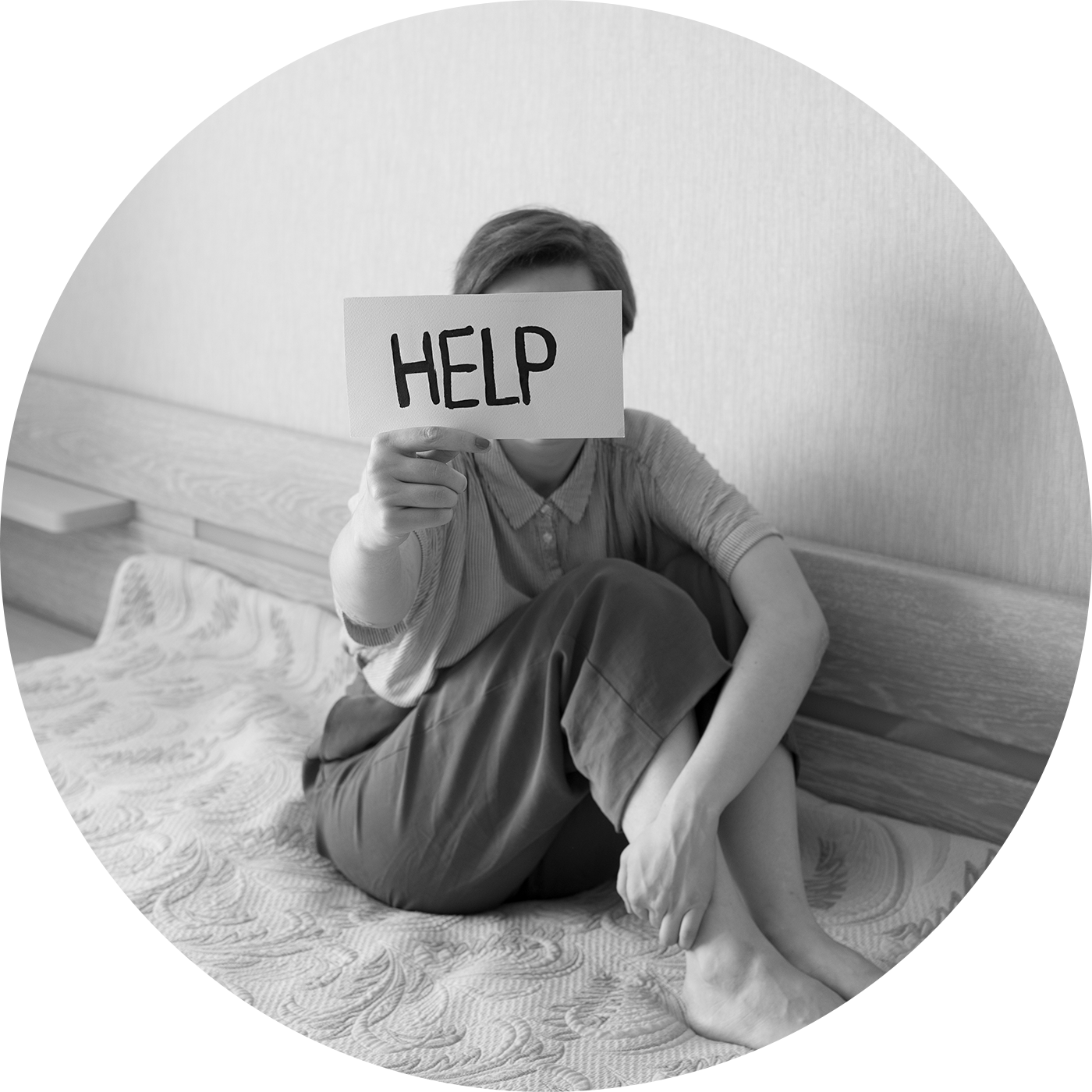 woman in bed holding up a HELP sign