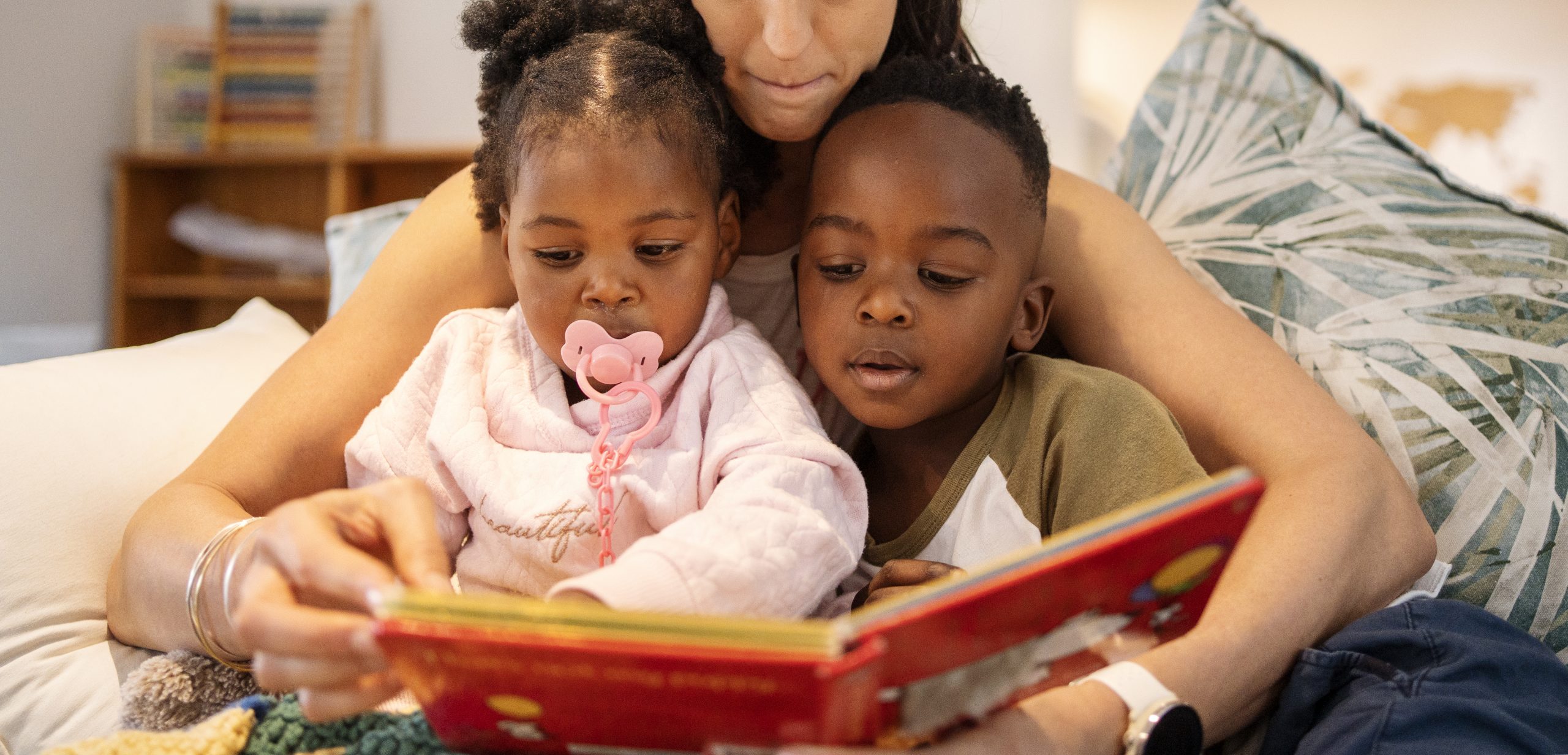 Mom reading a book to her cute adopted son a daughter